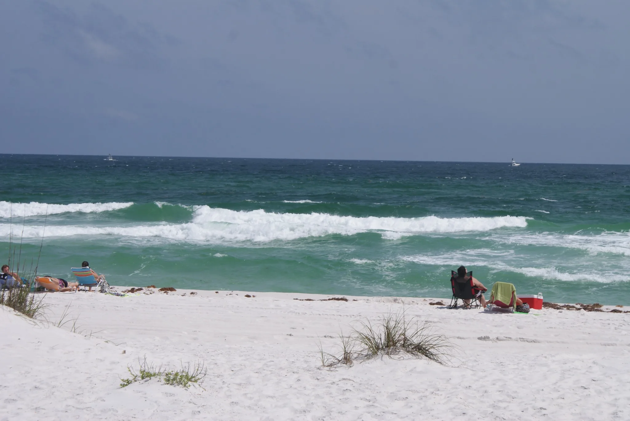 Beachgoers along the white sand and Gulf waters at Navarre Beach